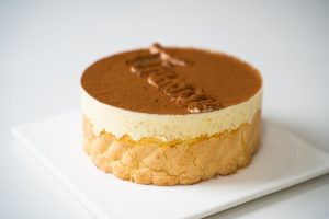Close-up of a delectable tiramisu cake with creamy layers and cocoa dusting.